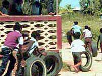 Children in Belize playing with tires